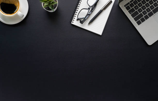 istock Workspace in office with black table. Top view from above of laptop with notepad and coffee. Desk for modern creative work of designer. Flat lay with blank copy space. Business and finance concept. 1226206385