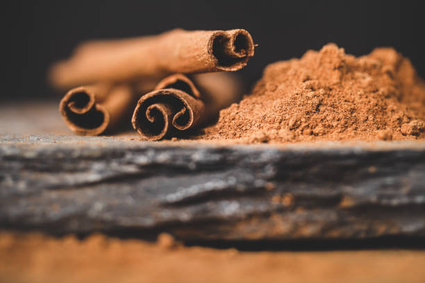 istock Cinnamon stick and powder on black background with stones. 1226210617