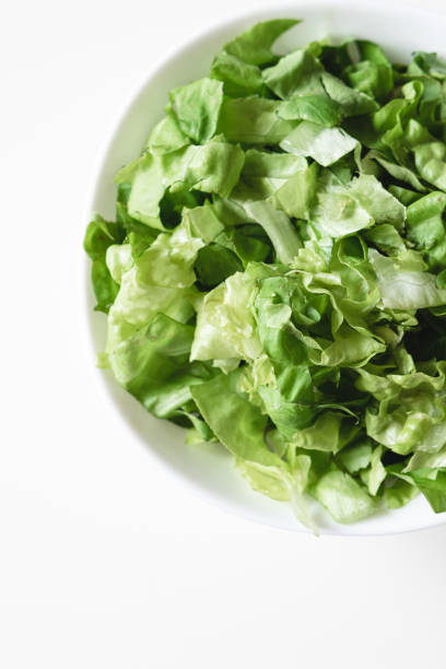 istock Top view of fresh-cut lettuce on a plate on a white background. 1226212082
