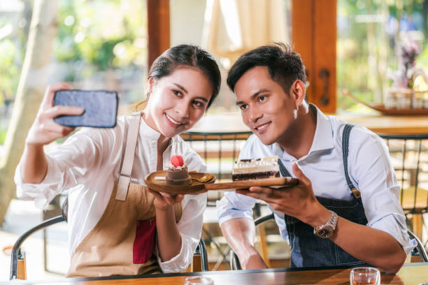 istock Colleagues Holding Dessert Taking Selfie In Cafe 1226213007