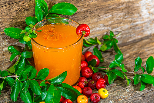 Fresh fruits and acerola juice (Malpighia emarginata). Acerola is a fruit rich in vitamin C, used in juices and ice cream. Tropical fruit. Energy drink. Natural and antioxidant drink.