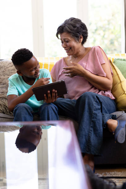 istock Mixed race boy and his grandmother Using digital tablet sitting on a couch 1226215403