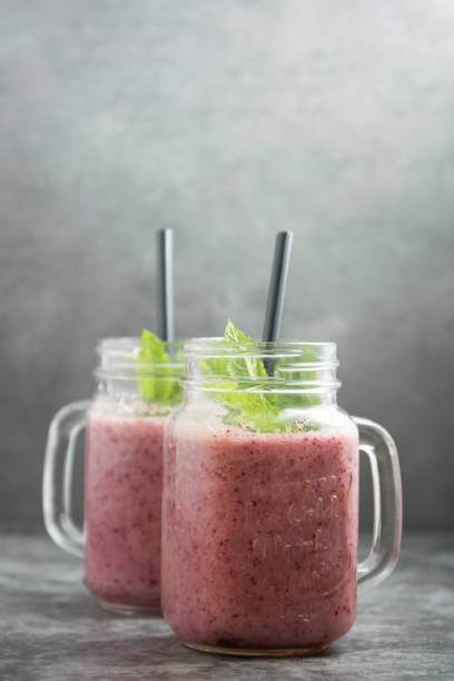 istock Two glasses jars with berry smoothie, grey background. 1226219974