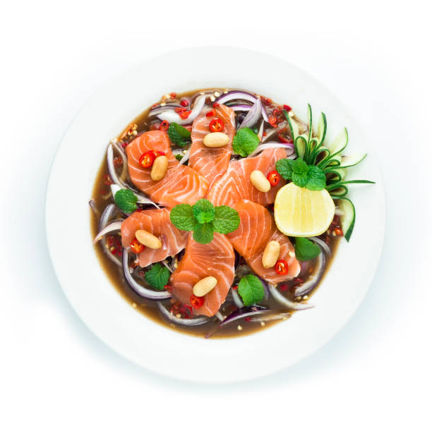 Salmon Spicy Salad in Pickled fish sauce Thai spicy Food decorate with cucumber and lime Asian Food stock photo