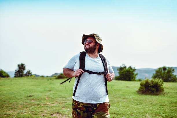 Bearded Male Enjoying Nature While Hiking On Grassy Hill