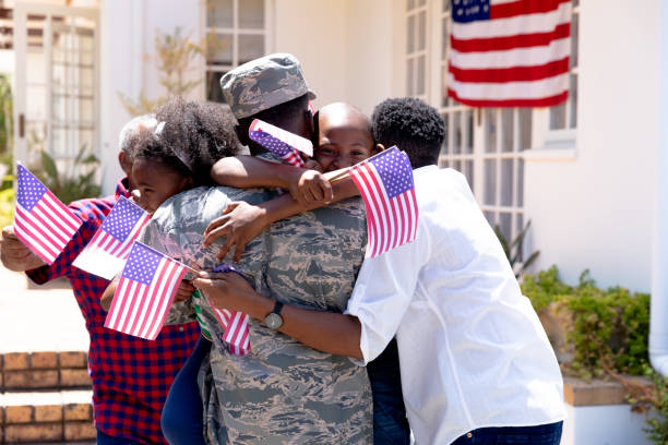 afro-americano soldado vestindo uniforme e sua família de pé ao lado de sua casa - traditional sport fotos - fotografias e filmes do acervo