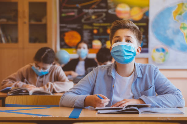 istock High school boy student at school wearing N95 Face masks 1226233874