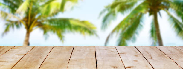 istock Wooden table on tropical beach coco palms background with copy space for banner. 1226237332