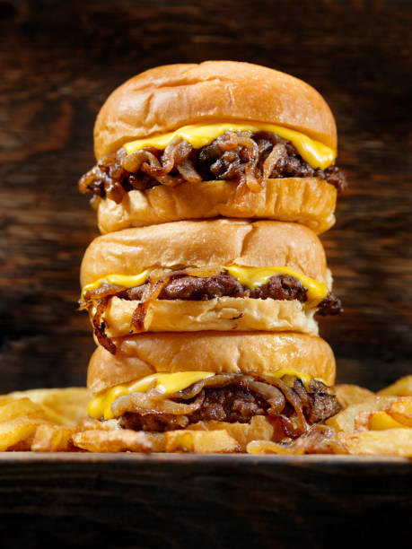 the famous fried onion smash burger with cheese and fries - smashed potatoes imagens e fotografias de stock