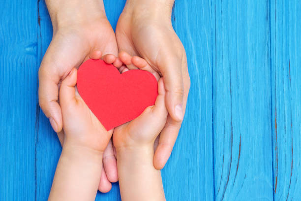 istock Child and dad hands holding red heart. 1226237683