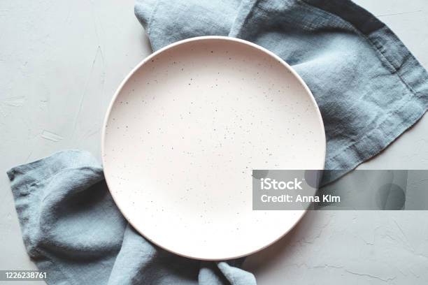 An Empty Plate And Napkin On The Gray Background Stock Photo - Download Image Now - Plate, Table, High Angle View