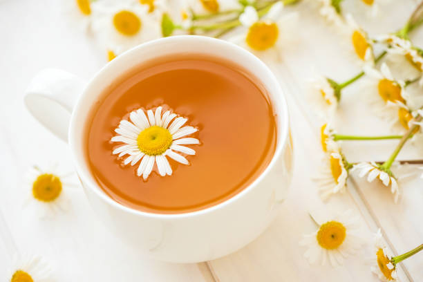 istock Herbal tea with fresh chamomile flowers on white wooden background. Soft focus 1226238926