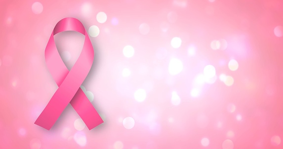 Pink Ribbon with a white lights on a pink background. Breast cancer concept.