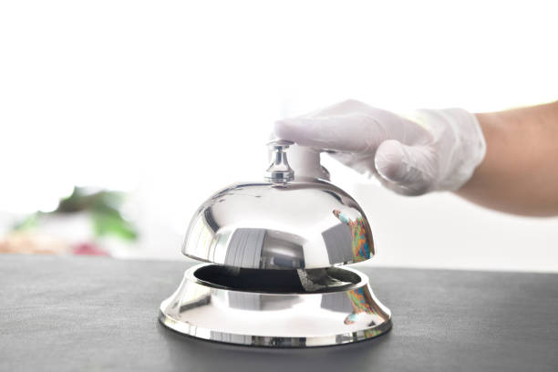 istock Male hand in protective gloves ringing hotel bell with copy space for your text 1226240074
