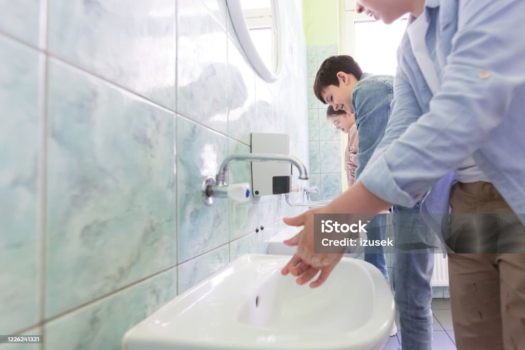 High school students washing hands Teenage boys washing hands in the school toilet. Close up of hands. Education Stock Photo