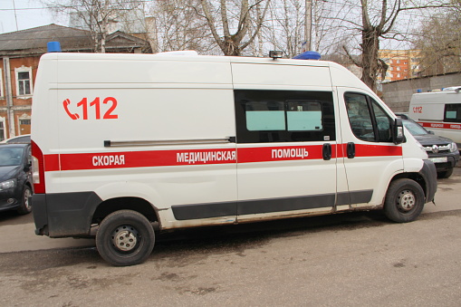 10-05-2020. Russia, Syktyvkar. White ambulance with a red stripe with blue flashing lights on a city street in Russia.