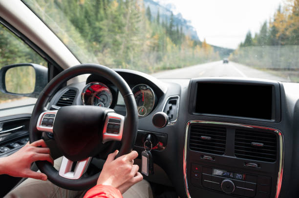 istock Man driving a car on the highway in autumn forest 1226242405