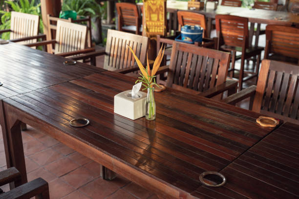 préparation de la table et des chaises en bois avec la fleur dans le vase et la serviette au restaurant - restaurant vehicle interior luxury indoors photos et images de collection