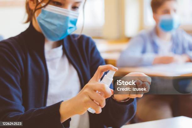 Teenage Girl Using Hand Sanitizer In The Classroom Stock Photo - Download Image Now - School Building, Education, UK
