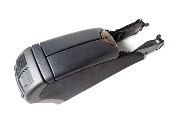 istock Plastic element of car interior is covered in black leather and with brown elements decorated like wood - armrest or a glove compartment - spare part with air conditioning holes on a white background. 1226246041