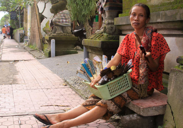 Local woman selling objects in Denpasar street stock photo