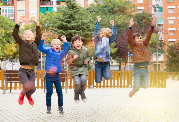 niños alegres juegan en la calle de la ciudad de otoño - child dancing preschooler outdoors fotografías e imágenes de stock