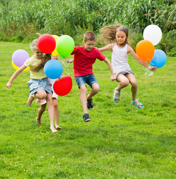 istock Kids jumping with multicolored balloons 1226248704