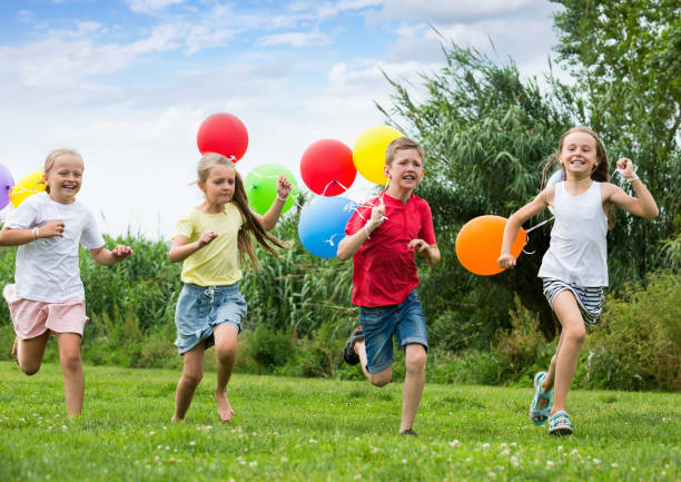 istock Playful kids running with balloons 1226248707
