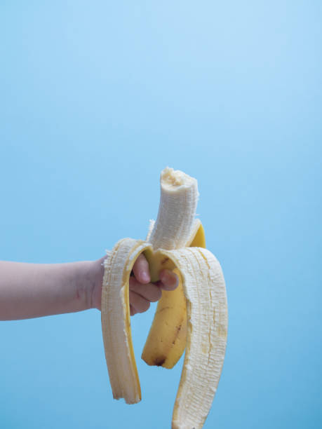 istock a childs hand holds a bitten banana 1226248980
