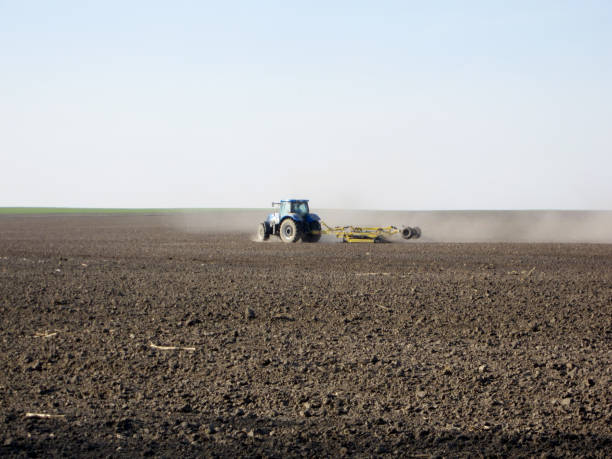 tractor Plowed field by tractor in brown soil on open countryside nature country road road corn crop farm stock pictures, royalty-free photos & images