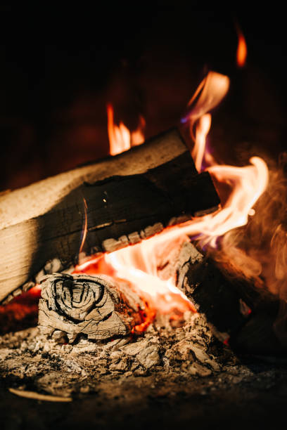 burning smoldering fire in a stone fireplace burning smoldering fire in a stone fireplace at home cricket trophy stock pictures, royalty-free photos & images