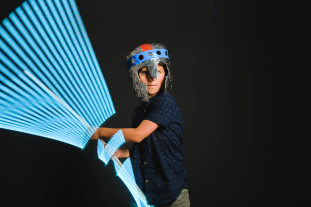 istock A kid with a light saber in his hands play in a superhero battle. 1226252945