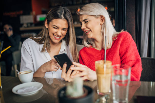 istock Two young women sitting in cafe and using smart phone 1226254383