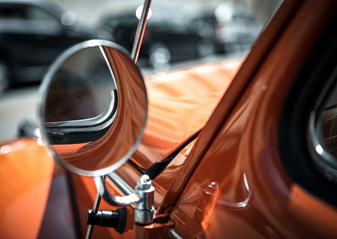 Left mirror of a classic car.
Photo taken outdoors in sunlight.