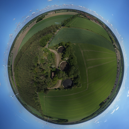 Little Planet, Spherical 360 degrees seamless panorama view in Spherical projection of a field and meadows with slurry tanks