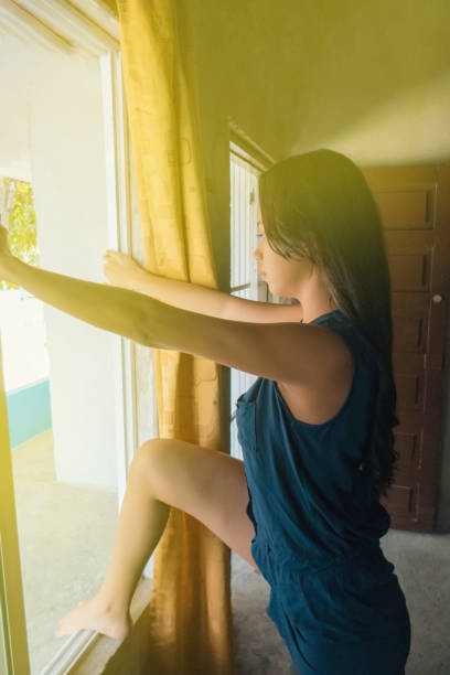 istock A young woman at home going out the window 1226258788