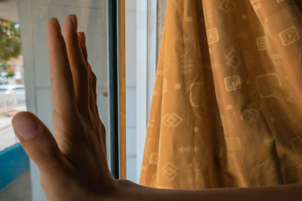 istock Hand of a woman touching windowpane 1226258861