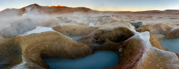 photo panoramique des geysers bleus au milieu d’un uyuni désert bolivien avec un ciel bleu sur un coucher de soleil et de la fumée sortant de la terre. mise au point sélective. - geyser nature south america scenics photos et images de collection