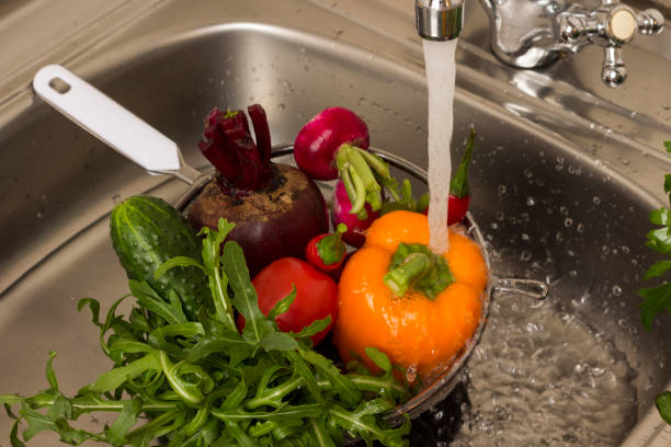 istock Vegetables in colander in sink under running water 1226263247