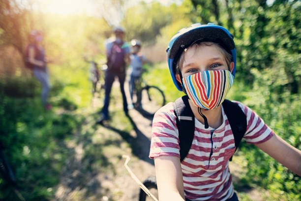 família curtindo uma viagem de bicicleta durante pandemia covid-19 - summer family clothing exploration - fotografias e filmes do acervo