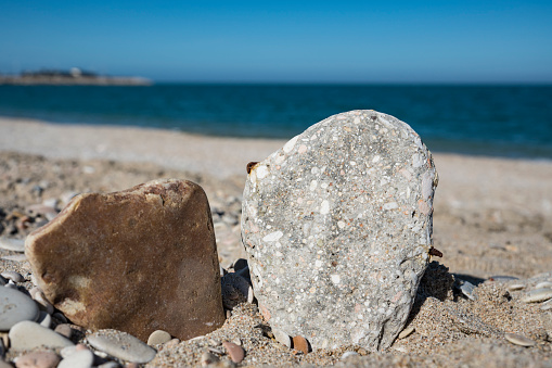Rock in the sand. Beach of Fano, Italy