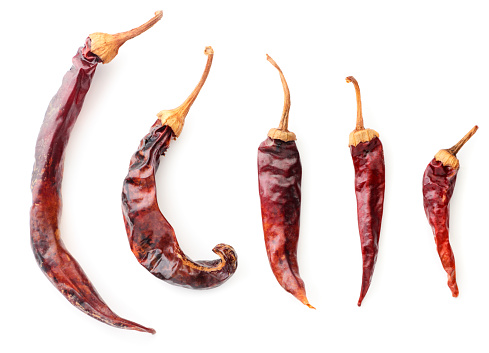 Collection of red dry chili peppers close-up on a white background. The view from top