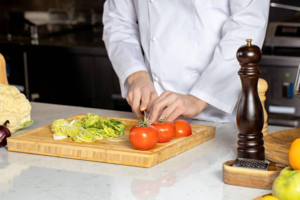 istock cropped cook man in apron cutting vegetables 1226267201