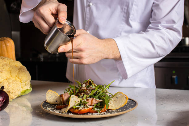 istock chef-cook gently pour the sauce on the salad 1226267335