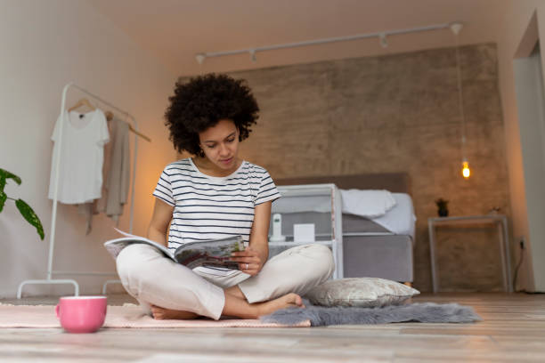 istock Woman reading a magazine at home 1226271097