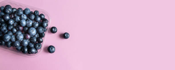 istock Ripe blueberry berries on a pink background with copyspace, top view, flat lay. 1226271620