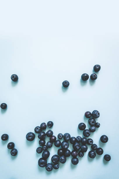 istock Tasty ripe blueberries pattern on blue background with space for text, top view, flat lay, vertical photo 1226272487