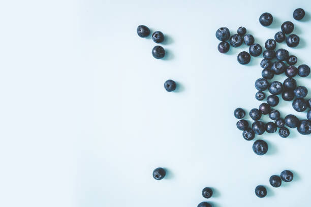 istock Tasty ripe blueberries frame on blue background, top view, flat lay with copy space 1226272739