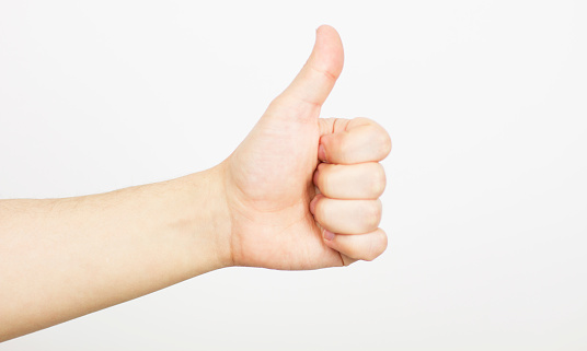 Image of young happy businessman over white background standing while make a selfie by camera and showing thumbs up gesture.