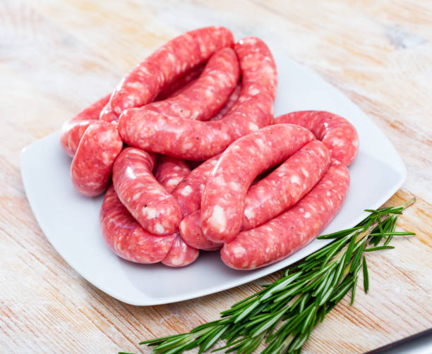 istock Raw sausages  for frying on wooden surface 1226278382